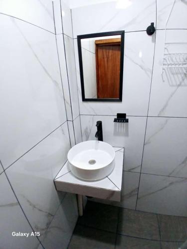 a white bathroom with a sink and a mirror at casa oasis in Tecomán
