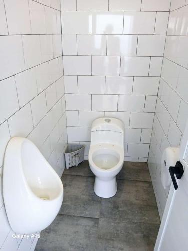 a bathroom with a toilet and a urinal and a sink at casa oasis in Tecomán
