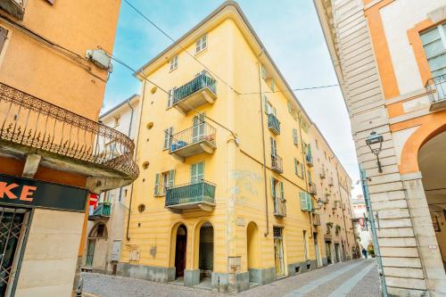 a yellow building on the side of a street at Petite Maison Cuneo in Cuneo