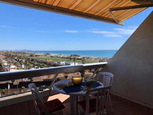 une table et des chaises sur un balcon avec vue sur l'océan dans l'établissement Résidence Héliopolis Bâtiment Ab - Studio pour 2 Personnes 454, au Cap d'Agde