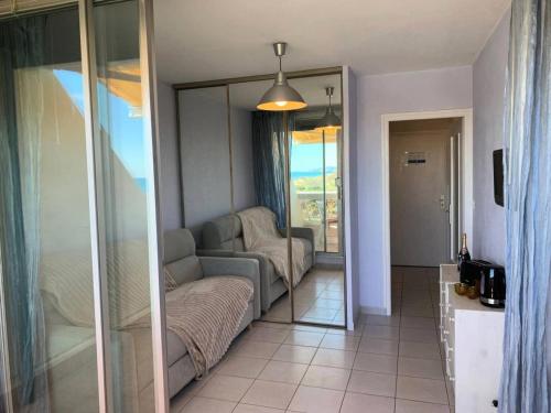 un salon avec un canapé et un miroir dans l'établissement Résidence Héliopolis Bâtiment Ab - Studio pour 2 Personnes 454, au Cap d'Agde