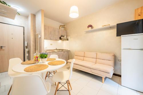 a kitchen and a living room with a table and chairs at Petite Maison Cuneo in Cuneo