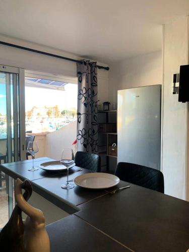 - une table à manger avec 2 verres à vin dans l'établissement Résidence Port Soleil Bâtiment B2 - Studio 2 Personnes - Port Soleil MAE-4431, au Cap d'Agde