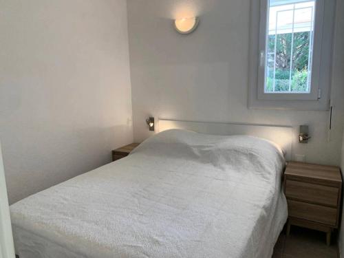 une chambre avec un lit blanc et une fenêtre dans l'établissement Résidence Port Soleil Bâtiment B1 - Appartement rez-de-chaussée 2 pièces - 2 pers - PORT SOLEIL MAE-1941, au Cap d'Agde