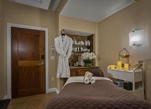 a room with a bed and a robe on a dummy at Inn By the Sea in Cape Elizabeth