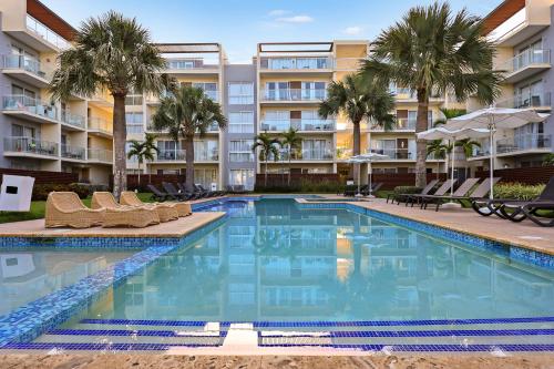 a swimming pool with chairs and palm trees in front of a building at 504 New, Fantastic Rooftop with Private Jacuzzi in La Laguna