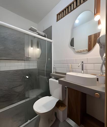 a bathroom with a toilet and a sink and a mirror at Casa dos Pássaros - AR Condicionado nos dois quartos in Lençóis