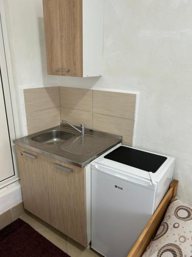 a small kitchen with a sink and a dishwasher at APARTMANI & RESTORAN -S O K O- SJENICA in Sjenica