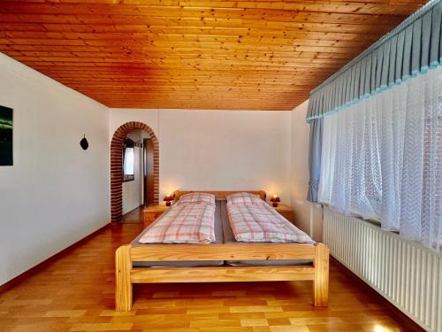 a bed in a room with a wooden ceiling at Pension Dang in Norddeich