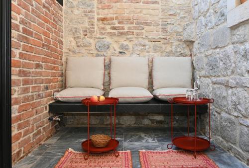 a bench with two white pillows and two red tables at MILIN DOM Premium Apartments in Split
