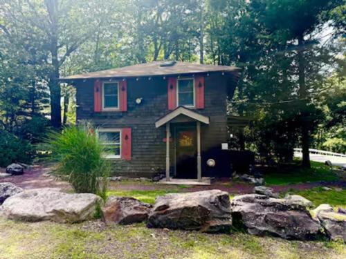 ein kleines Haus mit Felsen davor in der Unterkunft Cozy Cottage, Private Lake Access, Fires and Fun! in Lake Harmony