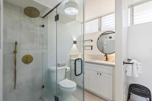 a bathroom with a toilet and a glass shower at A-303 Haleakala Shores in Wailea