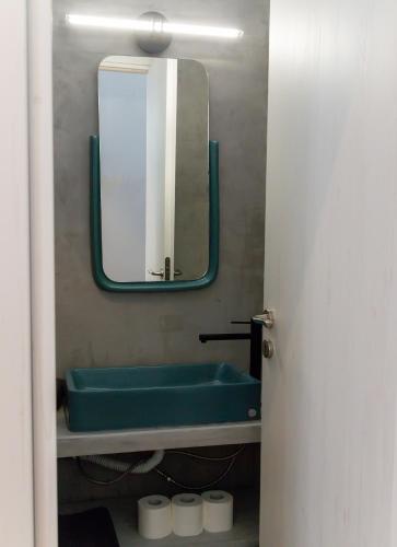 a bathroom with a green sink and a mirror at Byzantium Suite in the centre of Hermoupolis in Ermoupoli
