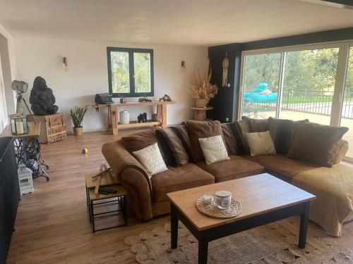 a living room with a brown couch and a table at Maison de vacances in Caussens