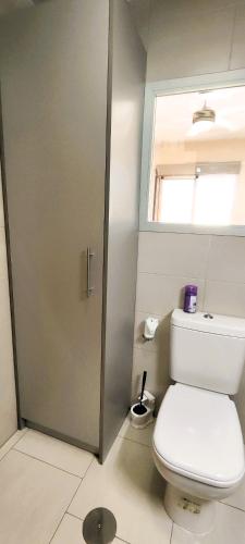 a bathroom with a toilet and a window at Apart Barlovento con piscina a 10 min de la playa in Águilas