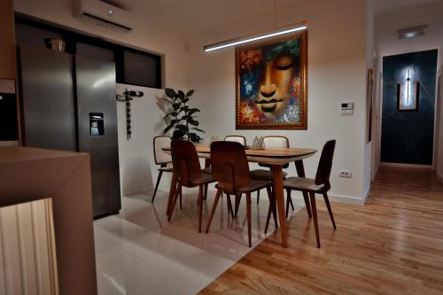 a dining room with a table and chairs and a painting at The Crown Pool Villa in Belgrade