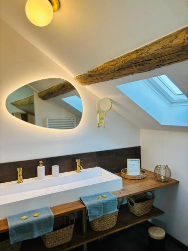 une salle de bain avec un lavabo et un miroir dans l'établissement Spa privé & évasion polynésienne à 20 min de Fontainebleau - PrestigeLodges, à Pamfou