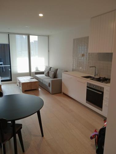 Una cocina y una sala de estar con un sofá y una mesa. en City views South Melbourne, en Melbourne