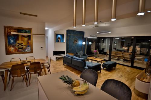 a living room with a couch and a dining room at The Crown Pool Villa in Belgrade