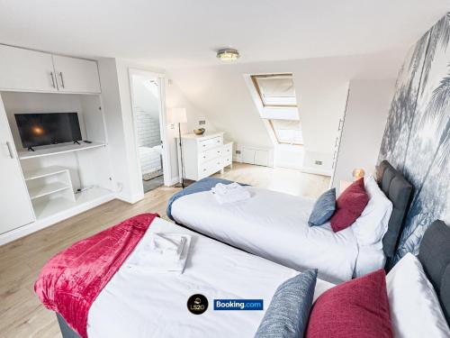 a living room with two beds and a tv at Spacious 5-Bed House with Parking in Wood Green by LS2G Stays in London