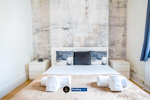 a bedroom with a large bed with two white towels at Spacious 5-Bed House with Parking in Wood Green by LS2G Stays in London