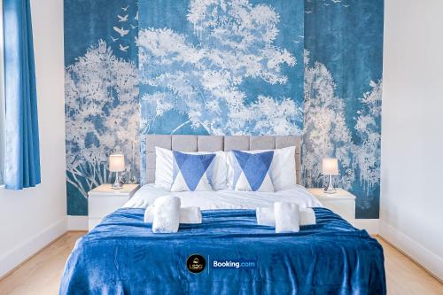 a bedroom with a bed with blue and white wallpaper at Spacious 5-Bed House with Parking in Wood Green by LS2G Stays in London