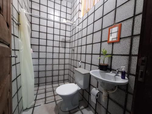 a bathroom with a toilet and a sink at Suíte perto do Centro e de Praias in São Luís