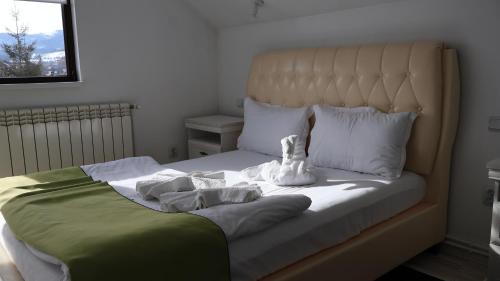 a bed with a white stuffed animal sitting on it at VILA RAISA in Neagra Şarului