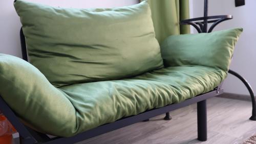 a green couch with a pillow on top of it at VILA RAISA in Neagra Şarului