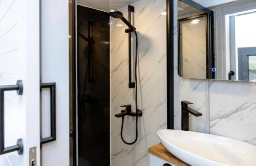 a bathroom with a sink and a shower at The Gatwick Cabin With Airport Parking Available in Horley
