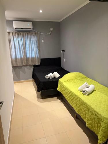 a bedroom with two beds with towels on them at DEL SOL APARt TERMAL V in Termas de Río Hondo