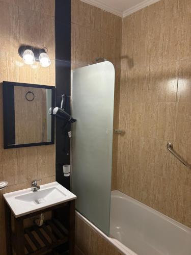 a bathroom with a sink and a tub and a mirror at DEL SOL APARt TERMAL V in Termas de Río Hondo