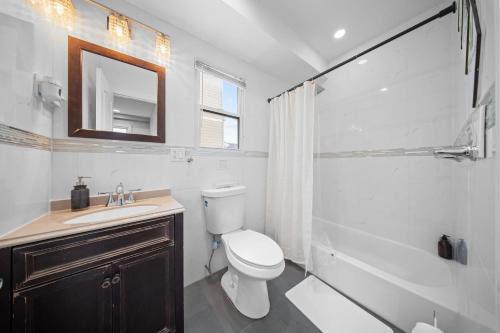 a bathroom with a toilet and a sink and a mirror at NYNJ World Cup 26 Fan Zone Queens Kasa Boho Rentals Sleeps 4 persons in Brooklyn Manor