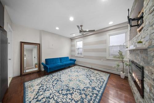 a living room with a blue couch and a fireplace at NYNJ World Cup 26 Fan Zone Queens Kasa Boho Rentals Sleeps 4 persons in Brooklyn Manor
