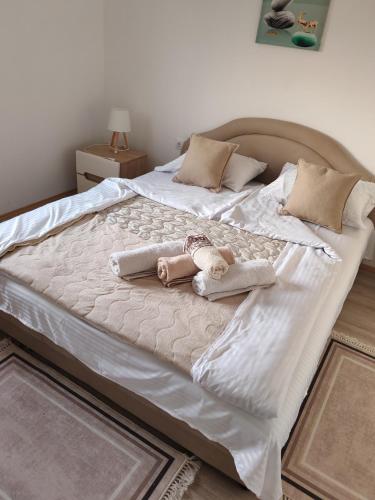 a large white bed with two stuffed animals on it at Sveti Luka- OBRADOVIĆ SOKAK 41 in Šimanovci
