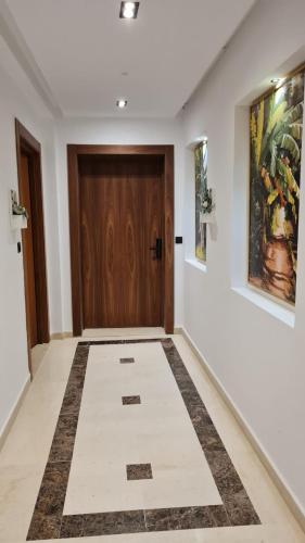 a hallway with a wooden door and a tile floor at Green Suites Tunis in El Aouina Station