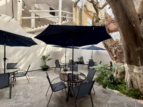 un patio avec tables et chaises avec parasols dans l'établissement CASA TORTUGA 5Th Ave, à Playa del Carmen