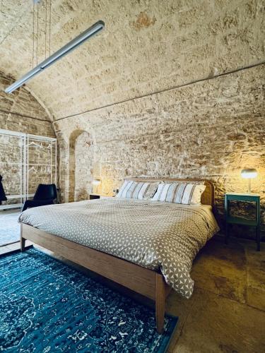 a bedroom with a bed in a brick wall at Il Magazzeno della Prozia in Corato