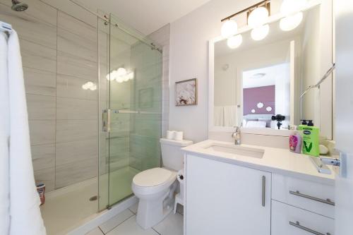 a bathroom with a shower and a toilet and a sink at Chic Hideaway-King Bed-Fireplace-DT-WEM-Garage in Edmonton
