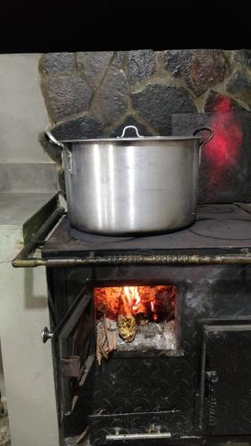 a pot on top of a stove with a fire at Quinta las Marias, Ecolodge, camping y Tiny wood house in Guateque