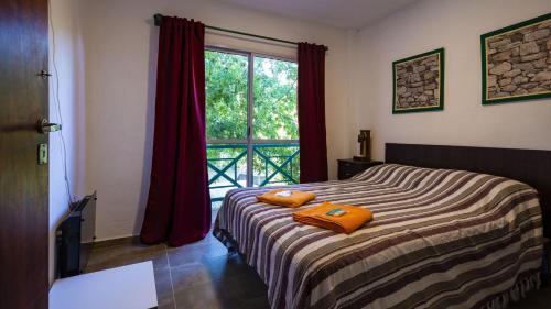 a bedroom with a bed with two orange towels on it at El Triunfo Apart - Departamentos Equipados Potrero de los Funes in Potrero de los Funes