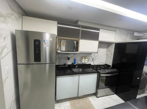 een keuken met een roestvrijstalen koelkast en een fornuis bij Apartamento para COP30 in Ananindeua