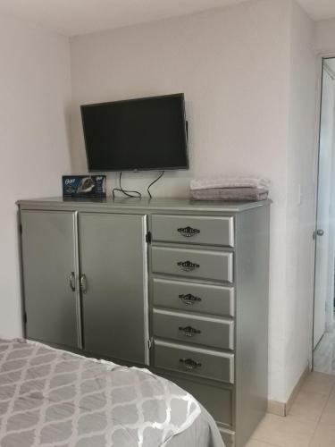 a bedroom with a dresser with a television on it at Balnearios, Casa villas la palma in Jojutla de Juárez