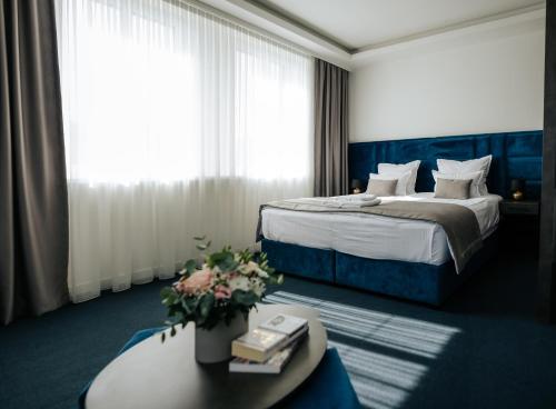 a hotel room with a bed and a table with flowers at Apartments Museum in Sarajevo