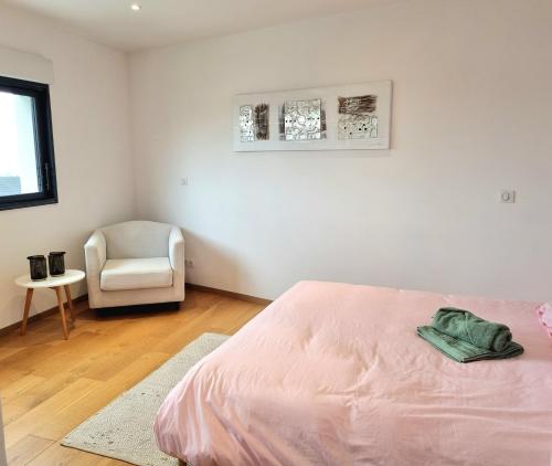 - une chambre avec un lit rose et une chaise blanche dans l'établissement Villa tout confort avec jardin - Location idéale pour vous détendre au calme, à Chanteloup-les-Vignes