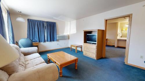 a living room with a couch and a tv at Western Executive Inn in Billings