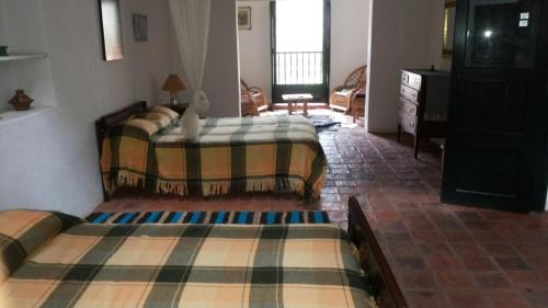 Una habitación con dos camas y una sala de estar. en Casa Mary Day, en Villa de Leyva