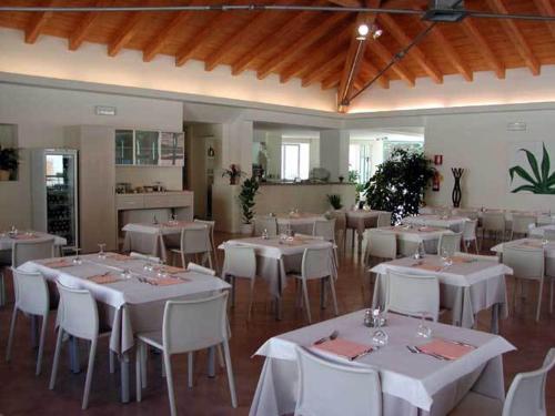a dining room with white tables and white chairs at Lieta Sosta in Colfiorito