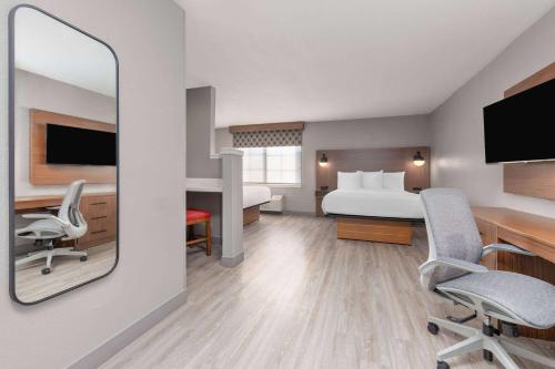 a hotel room with a bed and a desk at Hawthorn Extended Stay by Wyndham Bedford - Dallas in Bedford