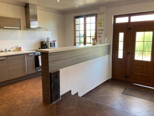 une grande cuisine avec un comptoir et une porte dans l'établissement L'ETABLE, à Desseling
